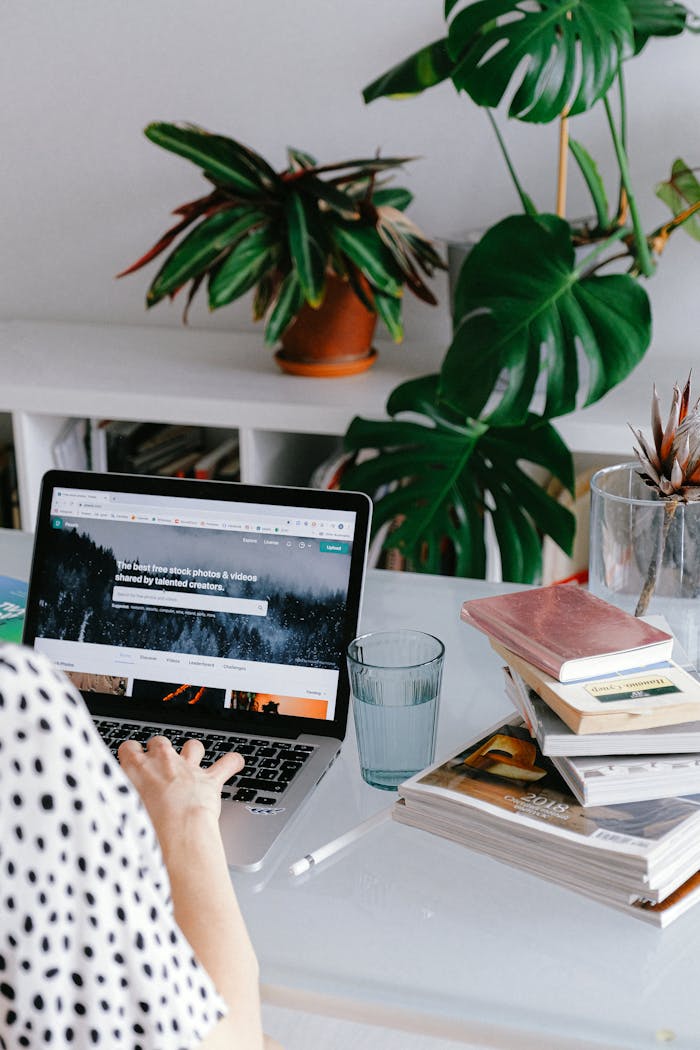 about-01 A woman working from home on her laptop surrounded by plants and books for a cozy office feel.